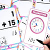 A close-up of colorful early learning flash cards showing numbers and shapes, with a hand holding a marker.