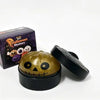 A black box and a golden pumpkin-shaped squishy stress relief toy are shown on a white background.