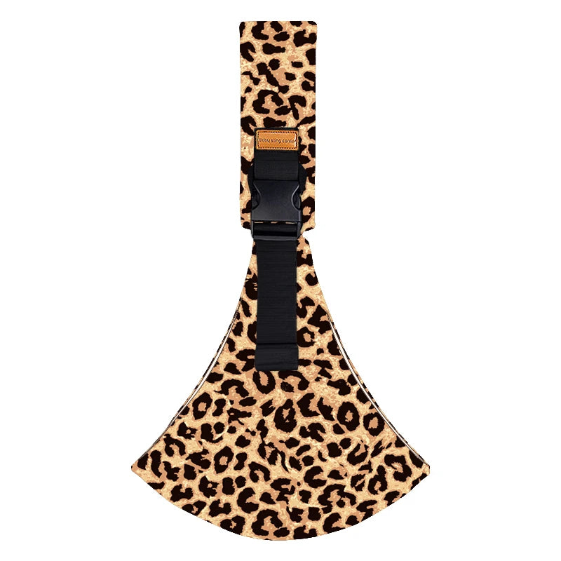 A black leather adjustable baby sling carrier with a leopard print fabric strap.