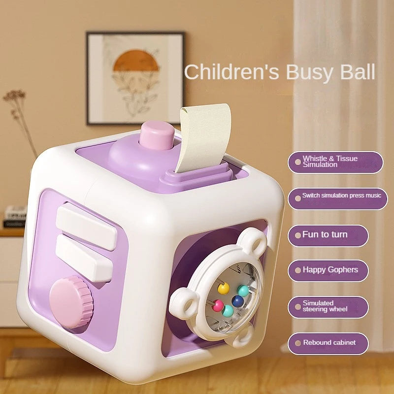 A white and purple children's busy ball cube with a simulated steering wheel and various sensory features.