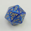 A blue polyhedral die with gold lettering, resembling a dragon or ancient script.