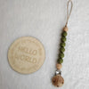 A string of natural wooden beads and a silicone teether attached to a cord on a white background.