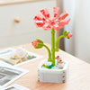 A pink rose flower building block bouquet set with green stems and leaves displayed on a white base.