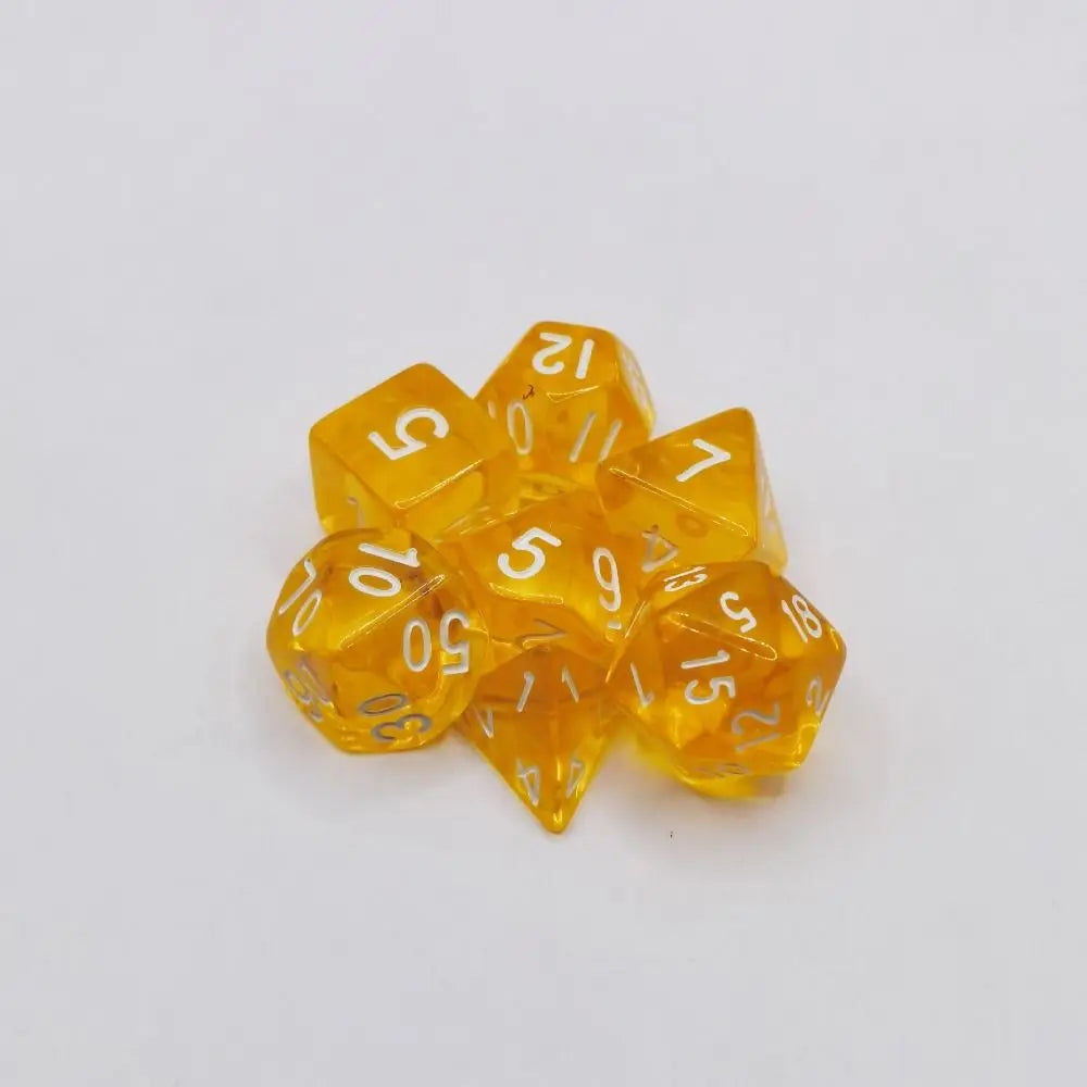 A collection of ten yellow acrylic polyhedral dice scattered on a white surface.