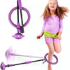 A young girl is playing with a purple glowing ankle skip ball and a long purple stick.