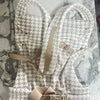 A beige and white patterned adjustable cotton baby carrier wrap laid out on a marble surface.