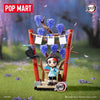 A POP MART collectible blind box figure of a character in Demon Slayer attire standing on a wooden base surrounded by blue fl