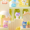 A collection of cute cat mini figurines in various colors and poses displayed on a light-colored desk setup.