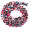 A circular arrangement of polished, multicolored beads made from natural sea sediment jasper and turquoise for jewelry making