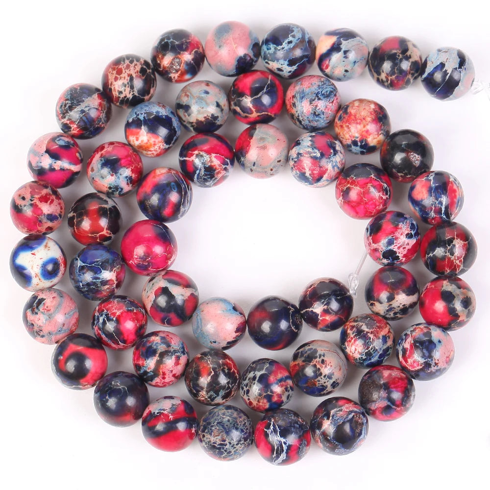 A circular arrangement of polished, multicolored beads made from natural sea sediment jasper and turquoise for jewelry making