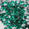 A pile of green and silver glass crystal flatback rhinestones for nail art and crafts.