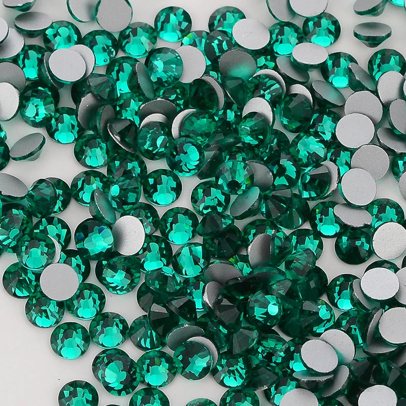A pile of green and silver glass crystal flatback rhinestones for nail art and crafts.