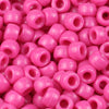 A close-up view of small, pink plastic pony beads for jewelry making and crafts.