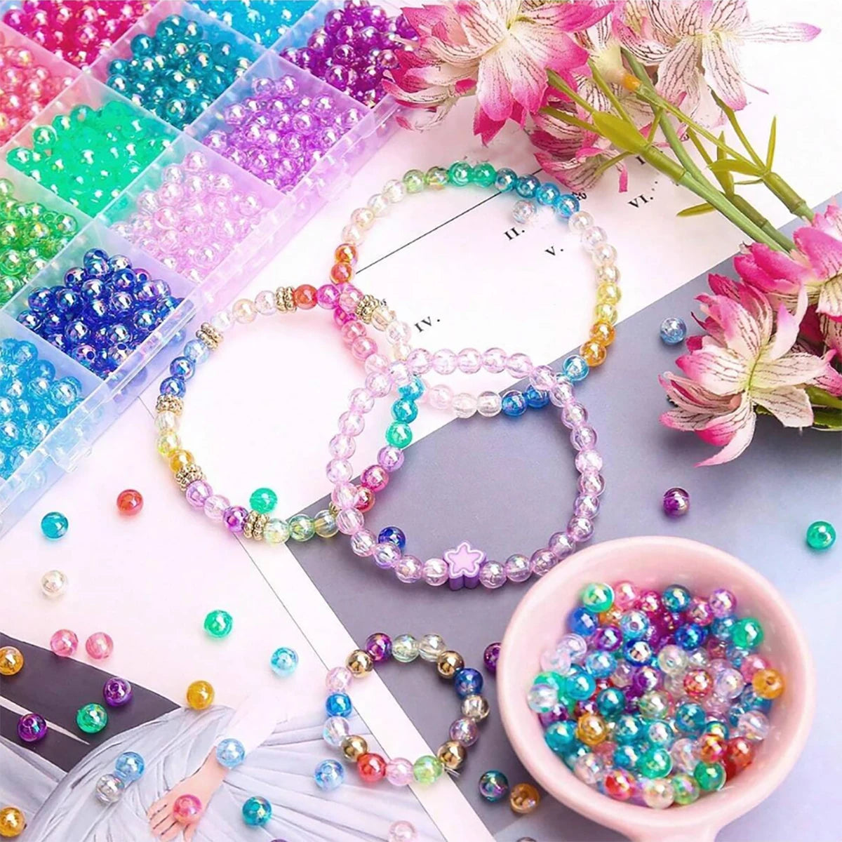 Assortment of mixed color resin beads and jewelry rings displayed on a white background.