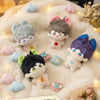 A collection of cute anime plush keychain charms in various colors and styles resting on a fluffy white surface.