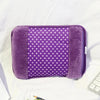 A purple fuzzy cover for a cozy rechargeable hot water bottle is shown on a white surface.
