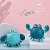 A blue wind-up swimming duck bath toy sits on a white surface against a pink background.