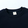 Navy blue kids pullover hoodie with a white tag visible on the chest