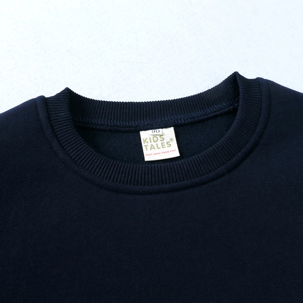 Navy blue kids pullover hoodie with a white tag visible on the chest
