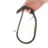 A hand is holding a realistic green snake prank toy with a string and clip.