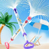 A white and purple pull-back water gun is shown firing a stream of water against a blue sky with a palm tree and beach settin