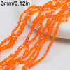 Orange crystal triangle beads strung on a string, shown close up.