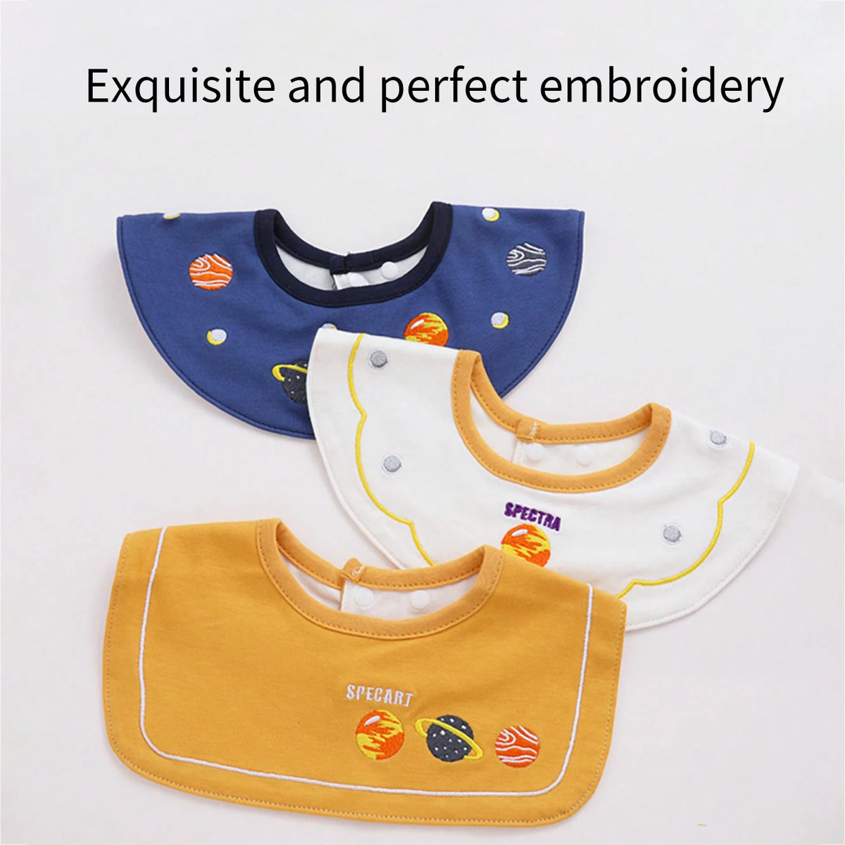 A set of three baby waterproof drool bibs in blue, white, and yellow with embroidered designs.