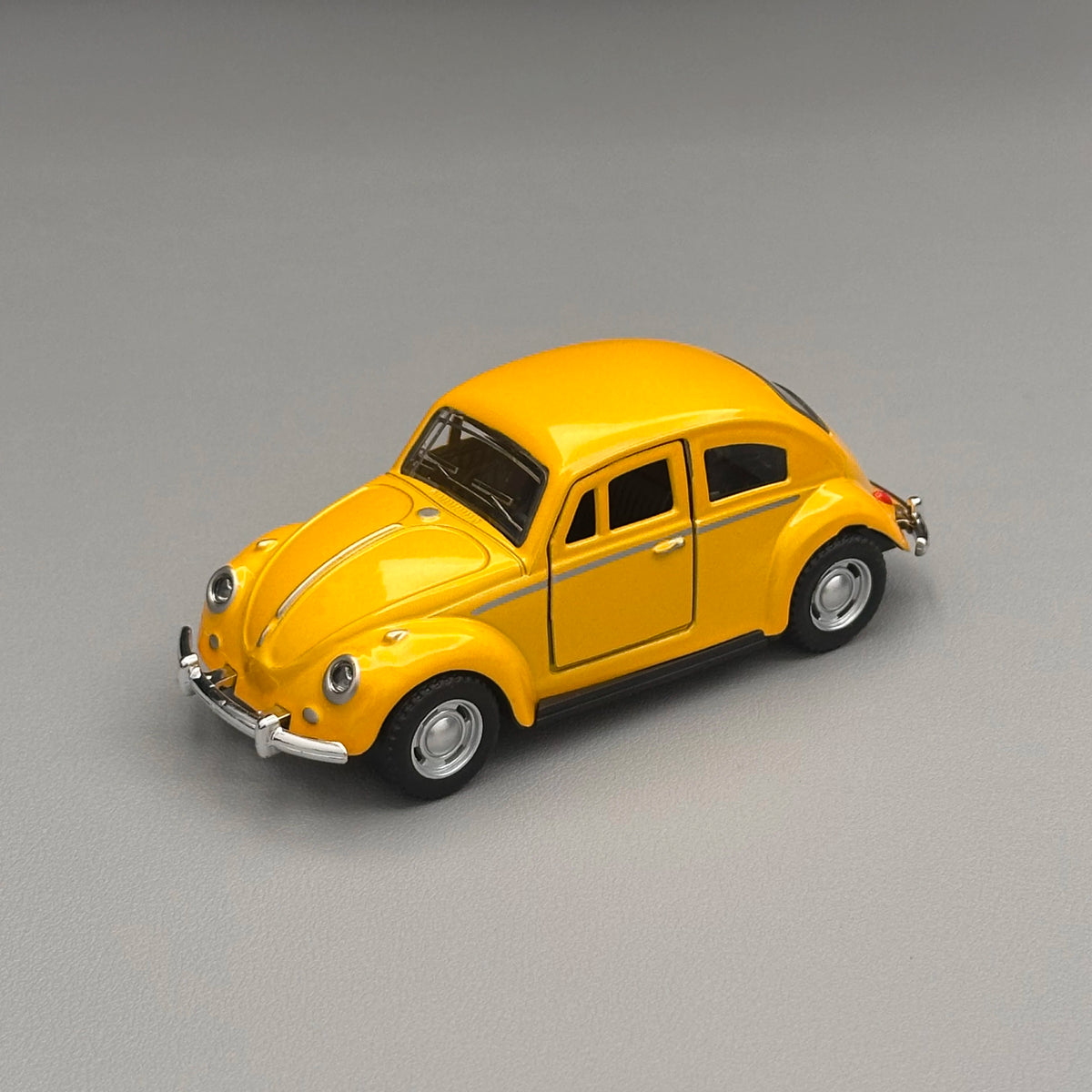 A yellow classic retro Beetle diecast model car with a black roof and chrome accents.