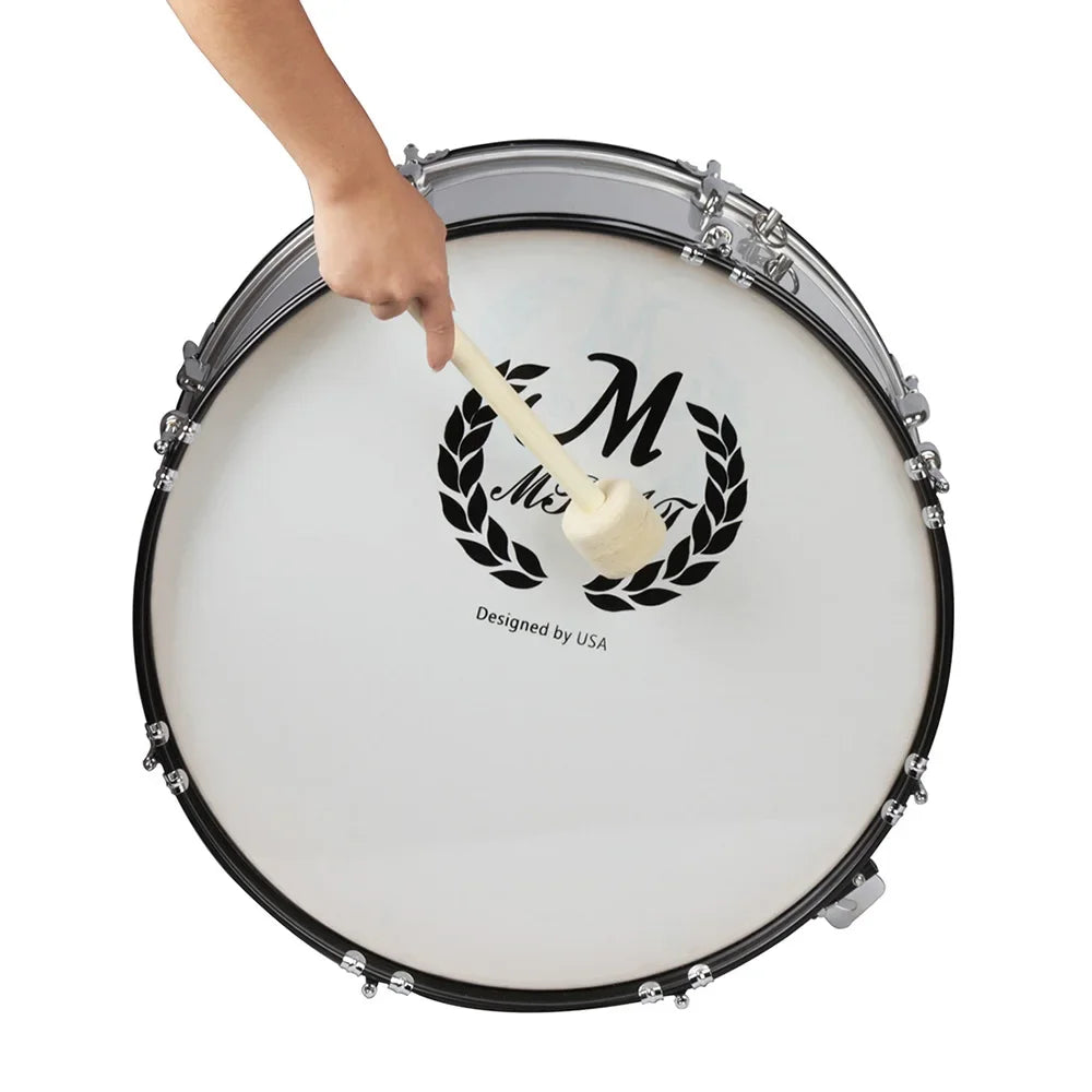 A hand is shown striking a white bass drum with a felt mallet, featuring an ornate design and silver hardware.
