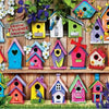 A collection of colorful wooden birdhouses and houses in various shades of blue, pink, yellow, and green arranged against a w