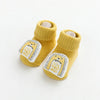 A pair of yellow cartoon non-slip cotton socks for babies and toddlers featuring a lion face design.
