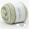 Spool of Fairyland long distance cake ball yarn in a gradient mix of green, blue, and cream.