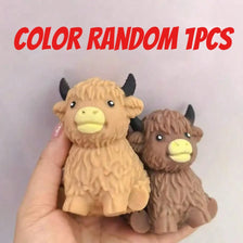 A hand holds a random 1pc Scottish Highland cow stress relief squishy toy.