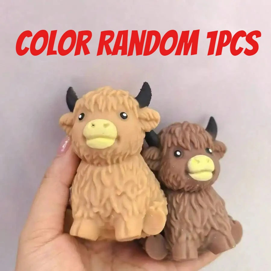 A hand holds a random 1pc Scottish Highland cow stress relief squishy toy.