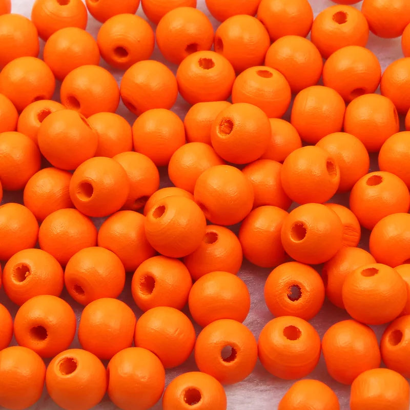 A pile of bright orange natural wooden beads for jewelry making and DIY crafts.