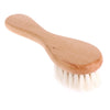 Peine de madera clara con cerdas naturales para el cuidado del cabello de recién nacidos.