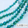 A strand of teal blue Austrian crystal beads with AB coating laid out on a white surface.