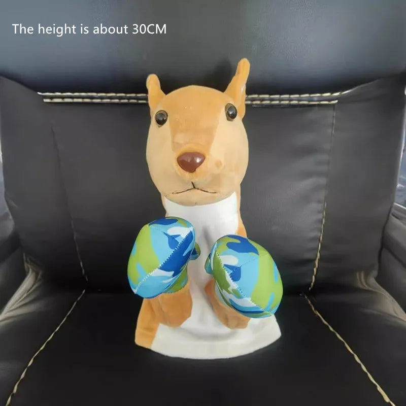 A plush toy resembling a dog or fox with light brown fur and blue patterned balls, displayed on a dark couch.