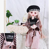 A princess doll wearing a pink outfit with black accessories and a black beret, styled for dress-up.