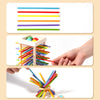 A hand is holding and arranging colorful wooden counting sticks and balance toys for early math learning.