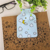 A light blue portable hot water bottle with a cloud and moon design resting on brown kraft paper.