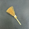 A golden straw broom used as a Halloween pumpkin costume accessory for dolls.