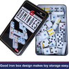 A black tin box containing 28 white and colored domino tiles for a game.