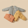 Two children's padded jackets, one blue-gray and one yellow, featuring letter prints.