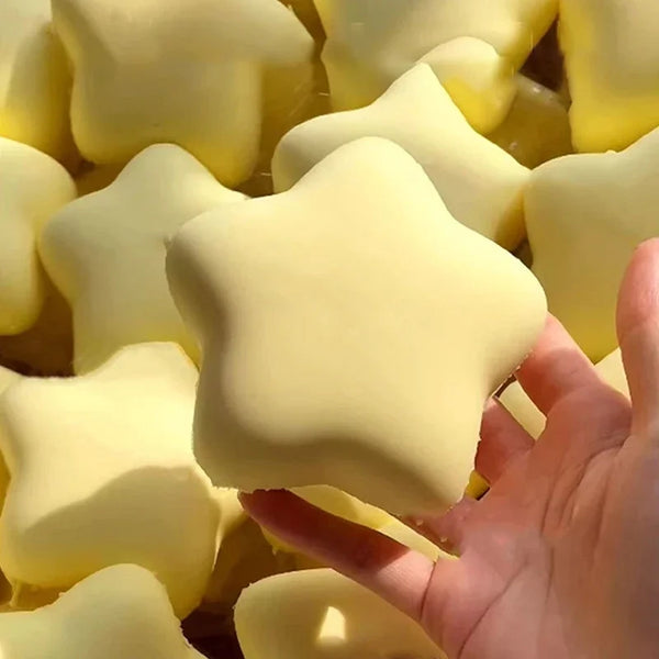 A hand is holding several yellow, soft squeeze star-shaped stress relief toys.
