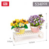 A set of 534 floral building blocks featuring yellow and purple flowers displayed on a white wooden shelf.