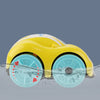 A yellow bath toy car with blue wheels is shown submerged in water.