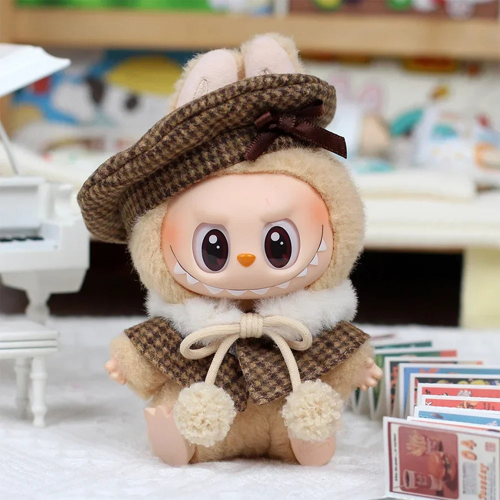 A cute, fluffy rabbit doll wearing a brown tweed beret and matching cape set.