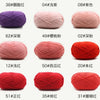 A collection of red and pink yarn balls showing various colors and textures for knitting and crochet projects.