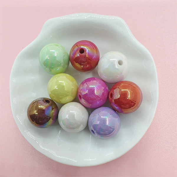 A collection of colorful acrylic magic round beads in various shades and opacities arranged on a white dish.